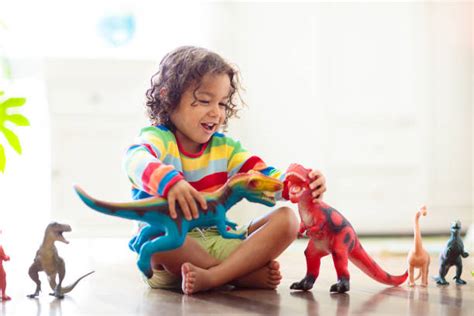 Un bambino che gioca con figure di dinosauri