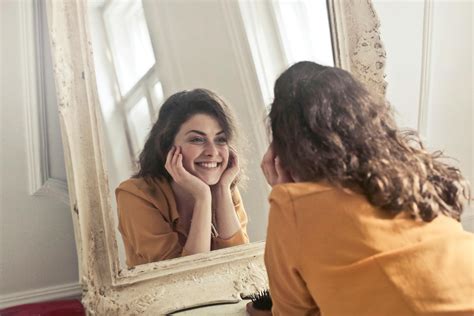 Donna che si guarda preoccupata allo specchio con i capelli in disordine