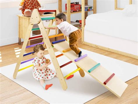 Bambini che giocano con un triangolo Pikler e una rampa