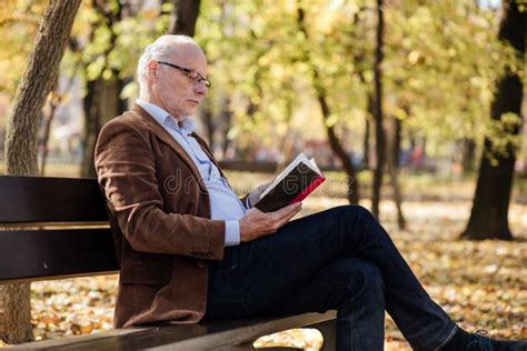 Anziano che legge un libro attentamente