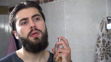 uomo che applica profumo