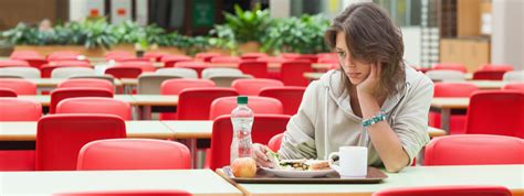 Persona che mangia da sola, con espressione preoccupata.
