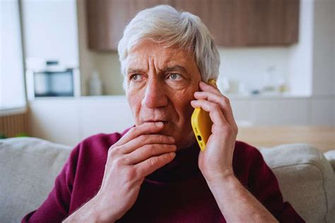 Adulto al telefono con espressione ansiosa, mentre un altro adulto si allontana