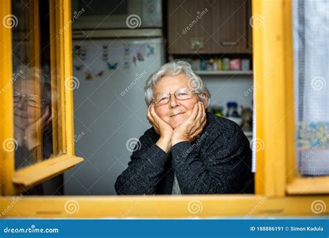 Immagine di una persona anziana che guarda fuori da una finestra, con un'espressione pensierosa.
