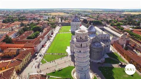 La celebre Torre Pendente di Pisa con turisti che interagiscono con essa