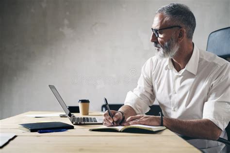 Adulto che lavora al computer con fogli sparsi