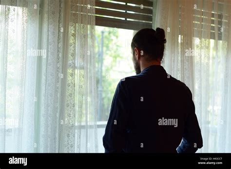 persona stanca che guarda fuori dalla finestra