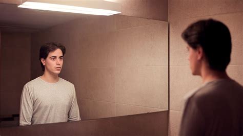 Persona che guarda nello specchio con espressione confusa