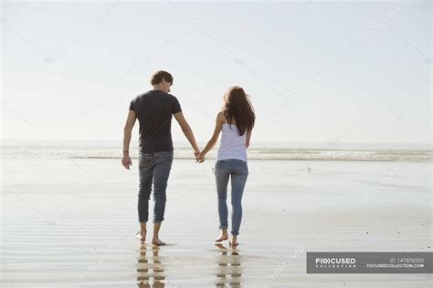 Coppia che cammina mano nella mano in un parco, simbolo di supporto e relazione