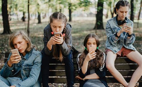 gruppo di adolescenti che usano smartphone insieme ma isolati
