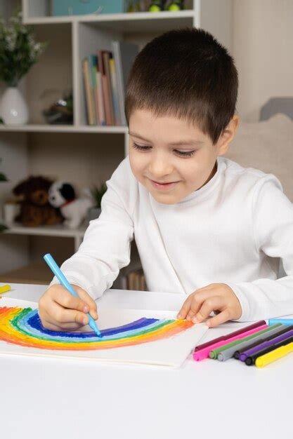 bambino che disegna un arcobaleno