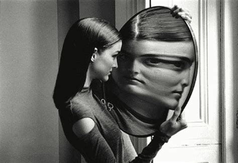 Persona con specchio in mano che riflette un volto distorto