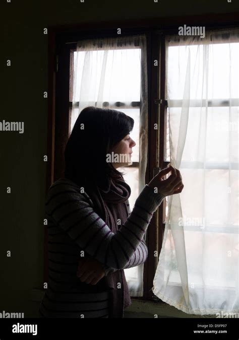 persona che piange guardando fuori dalla finestra