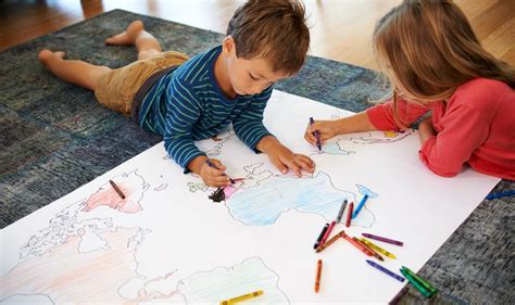 bambini che disegnano su grandi fogli all'aperto