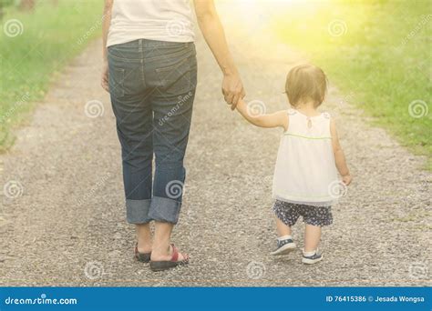 Una madre che tiene per mano il suo bambino mentre osserva una classe