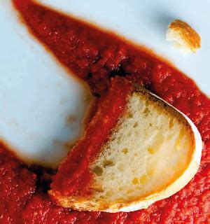 Mani che fanno la scarpetta con un pezzo di pane in un piatto di sugo