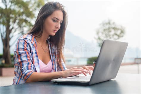Ragazza che scrive su un laptop in un parco
