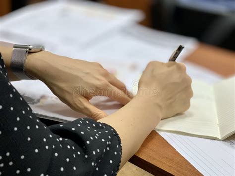 Ragazza che scrive su un quaderno, con una tazza di tè accanto