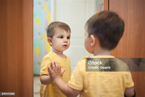 Bambino che si guarda allo specchio con un sorriso