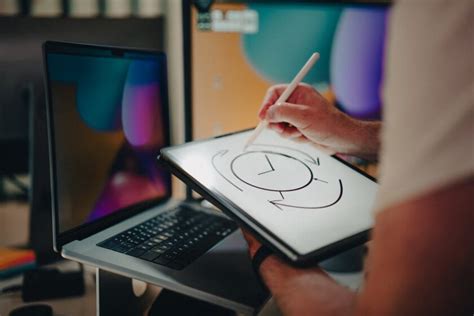 Una persona che disegna su un tablet grafico con uno sfondo colorato